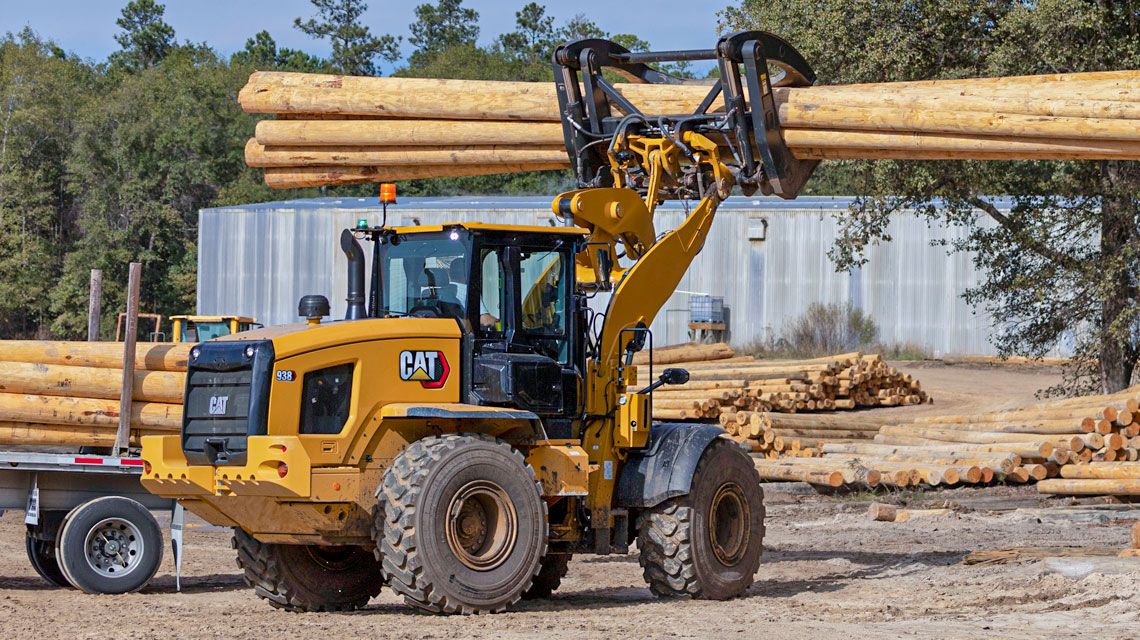 Wheel Loader picking up logs on a jobsite