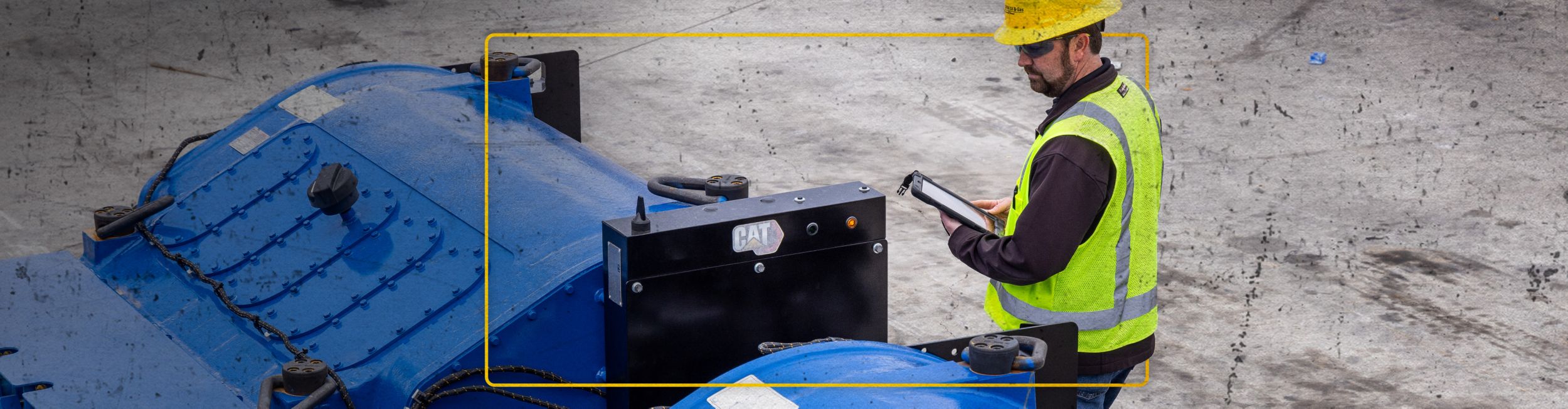 Cat worker observing Cat SPM equipment while holding a digital monitoring pad