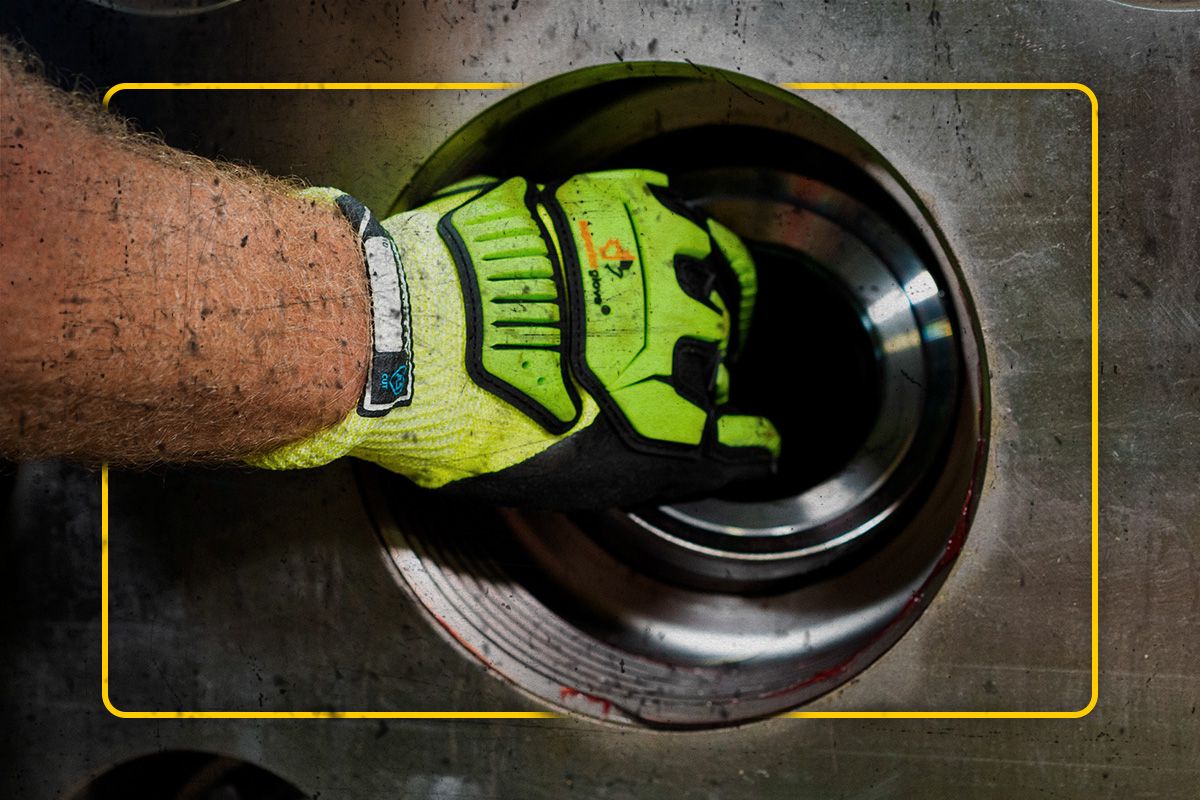 Close up of a Cat worker's gloved hands holding an SPM part