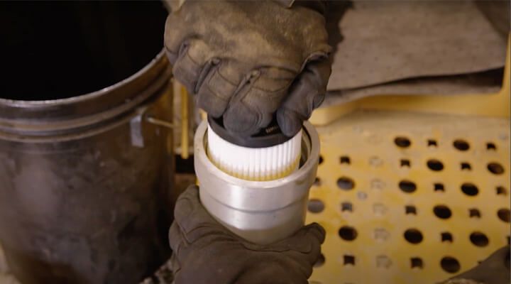 Technician installing a new filter on a Cat bulldozer