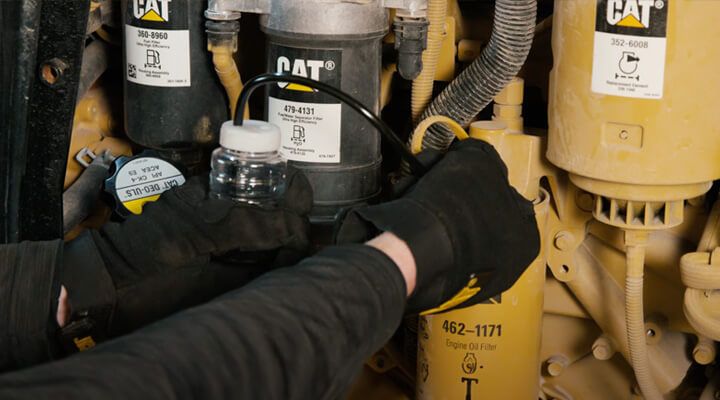 Technician drawing oil sample from machine