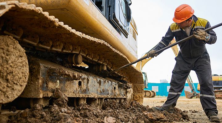 Person in hard hat inspecting undercarriage