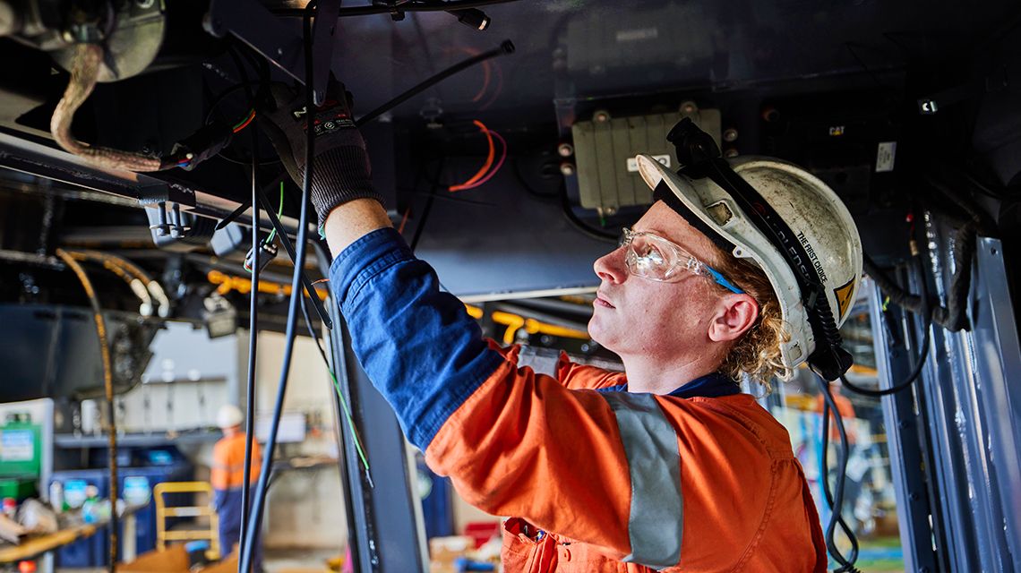 Person working on machine undercarriage