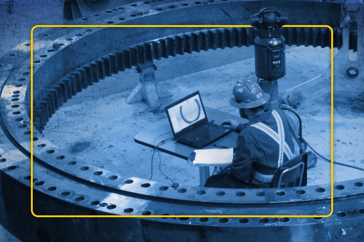 Tech doing computer diagnostics on large gear