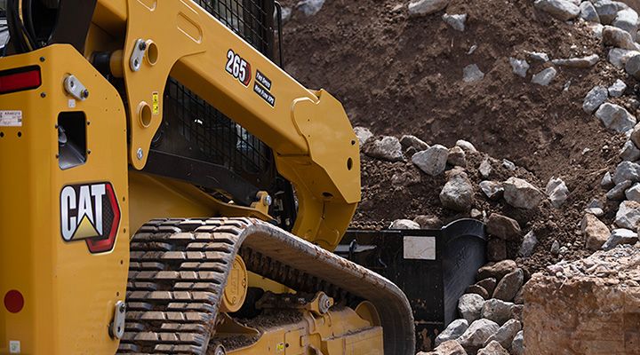 Compact Track Loader 265 scooping dirt on job site 